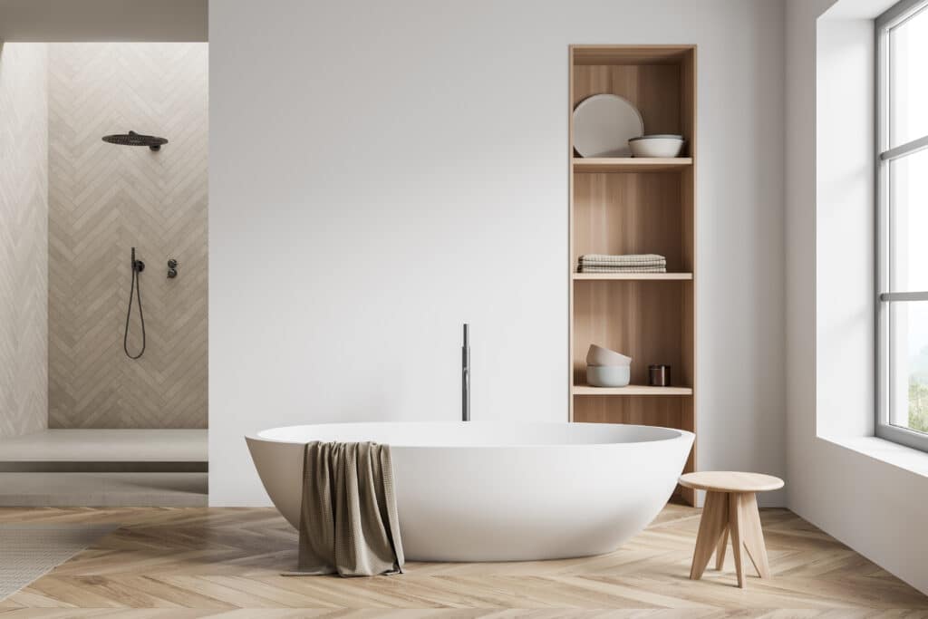 Salle Bain Moderne : Baignoire, Bois et Douche Design Salle de bain moderne avec baignoire îlot blanche, douche à l'italienne carrelée en chevrons et étagères en bois clair.